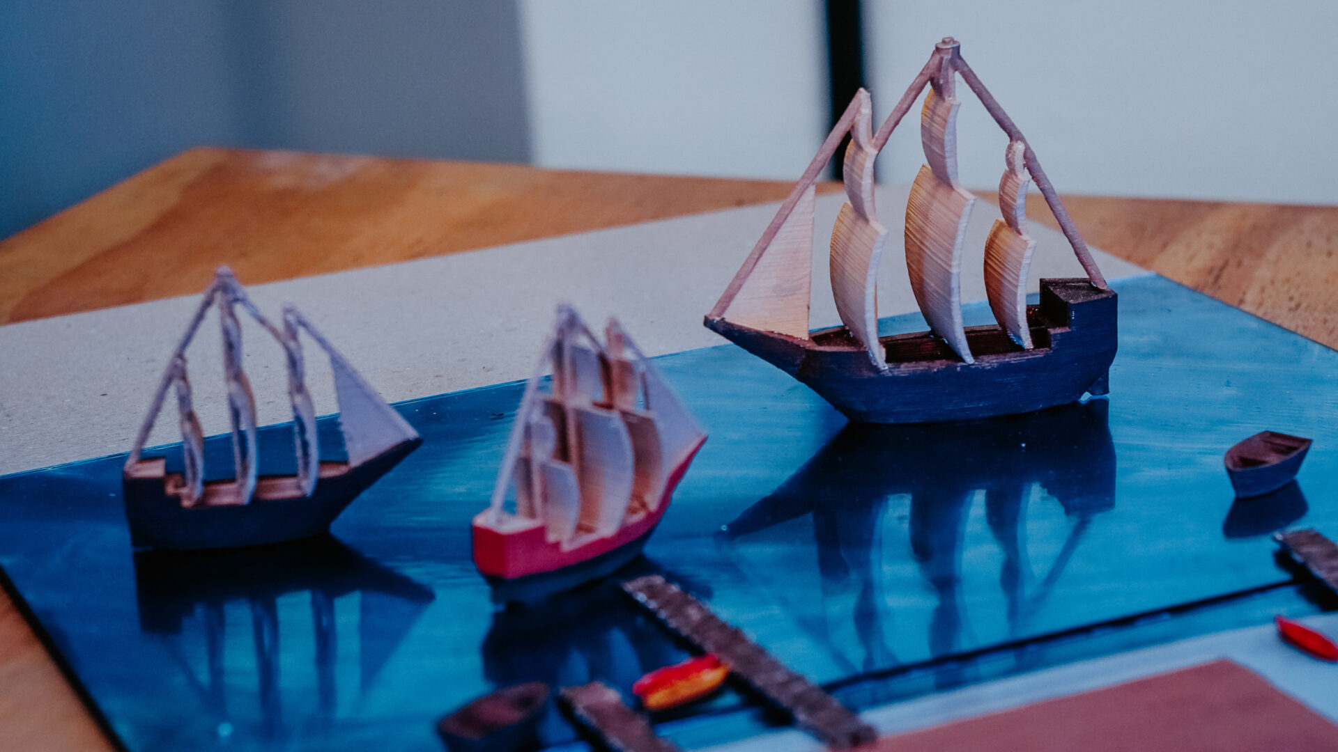 Veleiro em miniatura no mar de tecido azul